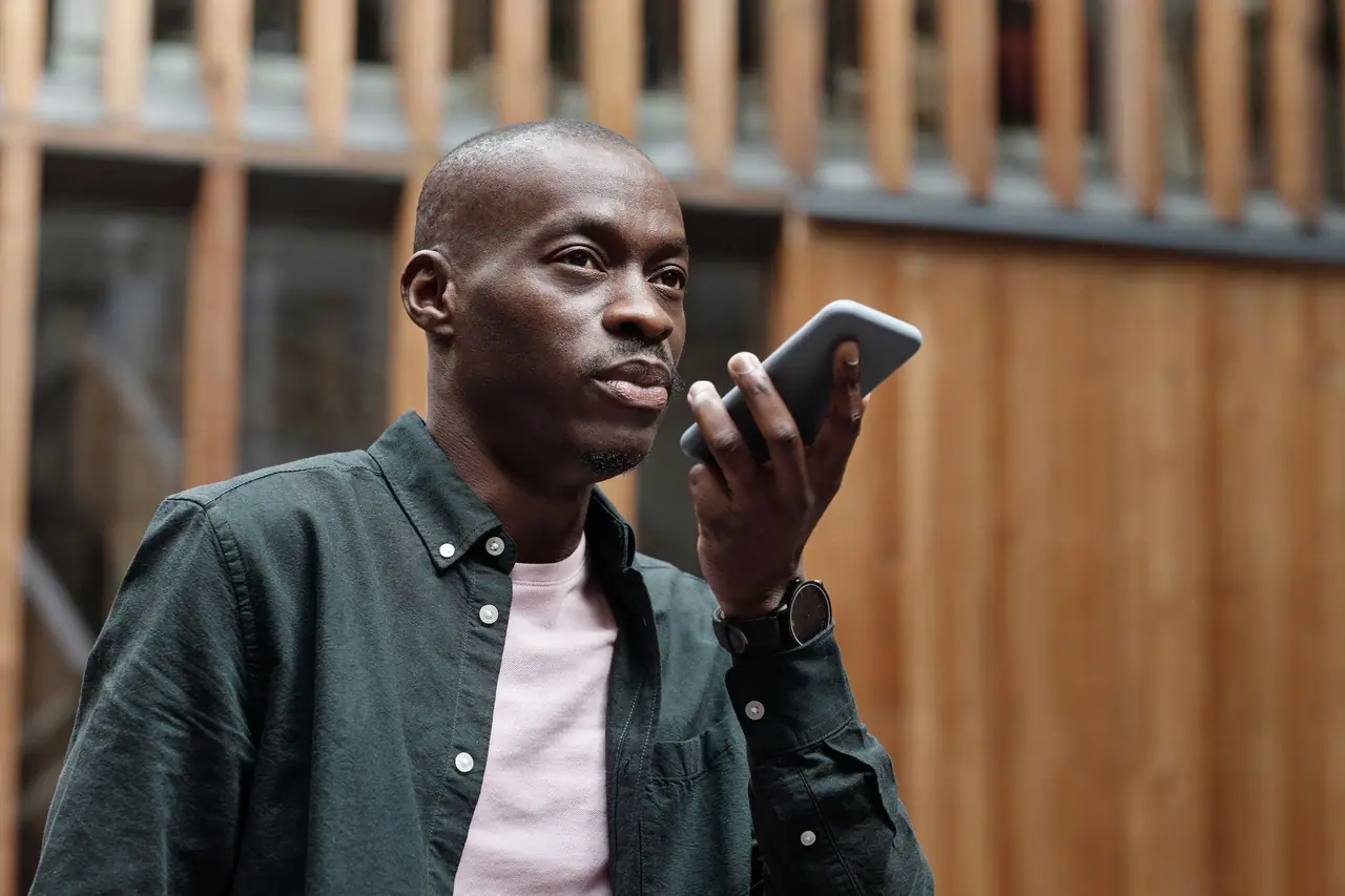 Personne posant une question à un assistant IA sur son téléphone