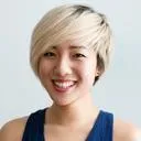 Femme souriante aux cheveux blonds courts, portant un haut bleu.